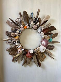 a wreath made out of driftwood and seashells is hanging on the wall