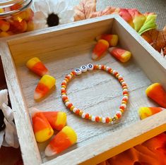 a wooden box filled with candy corn on top of a table