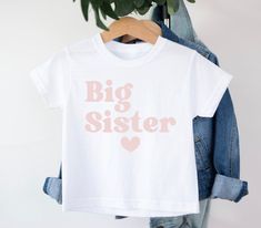 Big Sister t-shirt T-shirt is 100% Australian cotton.  We design & print our products with care & love! We use the best quality vinyls, inks & transfers on all products. * * * * * * * * * * * * * * * * * * * * * * * * * * * * * CARE INSTRUCTIONS: Wash inside out on gentle wash, Do not tumble dry. * * * * * * * * * * * * * * * * * * * * * * * * * * * * * SHIPPING: We want to get your product to you as quickly as possible, your purchase will be shipped through Australia post, Express post is available for selection. * * * * * * * * * * * * * * * * * * * * * * * * * * * * * GUARANTEE: We stand behind our products with a 100% guarantee; if you are unsatisfied with our product, please let us know & we will rectify any issues. We are unable to refund products due to change of mind or those that Unisex Family Matching T-shirt With Screen Print, White Short Sleeve T-shirt For Gender Reveal, White Print Name T-shirt In Cotton, White Print Name Cotton T-shirt, White Name Print Cotton T-shirt, Short Sleeve T-shirt With Name Print For Gender Reveal, Gender Reveal T-shirt With Name Print, White T-shirt With Name Print For Gender Reveal, White Letter Print T-shirt For Gender Reveal