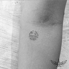 a black and white photo of a small tattoo