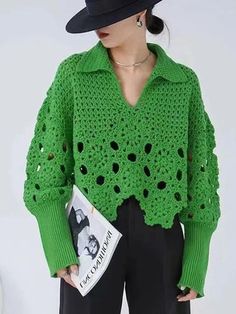 a woman wearing a green crochet sweater and black wide brimmed hat