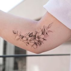 a woman's arm with a flower tattoo on the left side of her arm