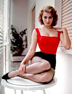 a woman sitting on top of a table wearing fishnet stockings