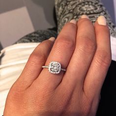 a woman's hand with a diamond ring on top of her finger and an engagement band