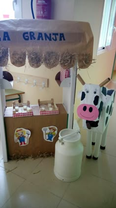 a cow is standing in front of an ice cream stand with cupcakes on it