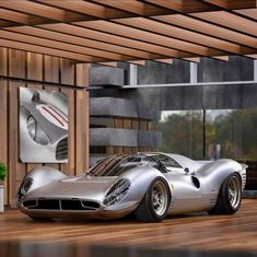 a silver sports car parked in front of a wooden building with windows on the side