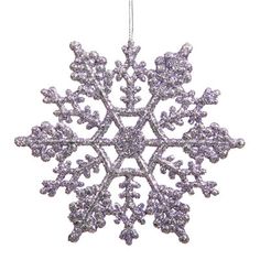 a purple snowflake ornament hanging from a white string on a white background