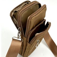 Wear as a crossbody or as a belt bag around your waist. Adjustable nylon strap. 3 separate zipper compartments. Zipper top closure. Our nylon material is lightweight and easy to keep clean with a damp cloth. • Built-in RFID protected to hold credit cards• Carabiner clip included• Nylon loop on back to wear on belt• 10 colors trendy solid colors 4.25”W x 7.5”H x 1.5”D Green Nylon Belt Bag With Adjustable Strap, Green Belt Bag With Zipper Closure, Brown Crossbody Bag With Turn-lock Closure, Brown Crossbody Wallet For On-the-go, On-the-go Crossbody Bag Strap With Removable Pouch, Carabiner Clip, Red And Teal, Kids Sandals, Zipper Top