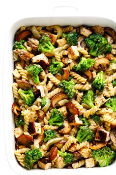 a casserole dish filled with pasta, broccoli and mushrooms