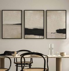 three paintings hang on the wall above a dining table