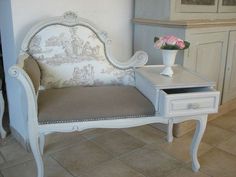 a white chair with a flower vase on top of it next to a small table