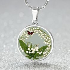 This May Birth flower Necklace features a delicate and beautiful butterfly charm, paired with the delicate and elegant Lily of the Valley flower, the birth flower for the month of May. Created with our patent-pending design, this necklace is made of high quality surgical steel with the option of an 18k gold finish for added luxury. This necklace is the perfect keepsake for yourself or a loved one, and can be customized with a special photo of your choice. You can also opt for custom engraving on May Birth Flower, May Birth Flowers, Birth Flower Necklace, Lily Of The Valley Flowers, Month Of May, Luxury Necklace, Butterfly Charm, Birth Flower, Birth Flowers