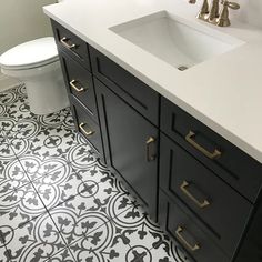 a white toilet sitting next to a black and white bathroom sink under a faucet