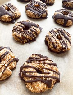 cookies with chocolate drizzled on them are sitting on a baking sheet and ready to be baked