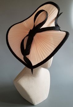 The most alluring swirl of jinsin straw, in a delicate peach, trimmed in fine black milan straw braid. The tilt of the black milan straw bow highlights the face framing curves of this seductive style. Comfortable headband, elastic, and comb attachment for easy all day wear. Custom shading of the headband and elastic, to match your hair color, is complimentary. Lifted Millinery headwear is constructed with time honored techniques and fine craftsmanship. All headwear is meticulously blocked and se Bows Aesthetic, Headband Elastic, Seductive Style, Luxury Hats, Church Hat, Comfortable Headbands, Wedding Hat