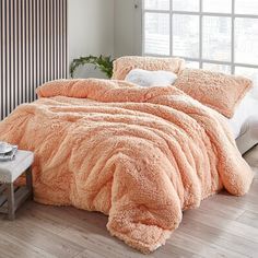 a bed with an orange comforter and pillows