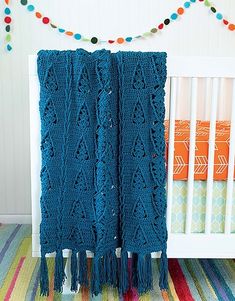 a crocheted blanket draped over a crib