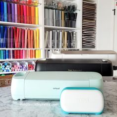 the cricut machine is sitting on the counter in front of many different colored crayons