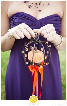 a woman in a purple dress is holding an ornament with pumpkins on it