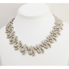 This is part of Chairish’s Costume Jewelry assortment.  Modernist rhodium plated textured squiggle links necklace with hook clasp. Marked "Monet." Center measures: 15/16 inches long. The maximum interior circumference is about 17 3/4 inches. Excellent condition. A wider version of this necklace was featured in a 1958 advertisement.  Please reference the measurements noted in the description above for the best approximate dimensions. Please reach out to the seller under "Ask the Seller" for speci Modern Silver Necklace With Hooks And Links, Textured Silver Metal Jewelry, Formal White Gold Necklaces With Hook And Links, Formal White Gold Necklace With Hook And Links, Elegant Textured Silver Jewelry, Formal White Gold Necklaces, Formal Sterling Silver Necklaces, Hook Clasp, Modern Branding