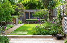 an outdoor garden with lots of plants and trees