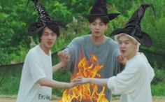 three boys wearing witches hats around a fire