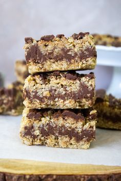 three chocolate and oatmeal bars stacked on top of each other in front of a plate