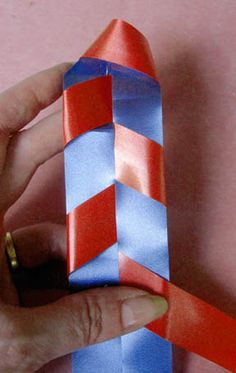 a hand is holding a red and blue tie