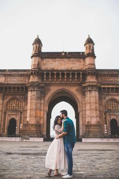 a man and woman standing in front of an old building