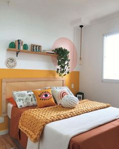 a bed sitting in a bedroom under a window next to a wooden shelf with books on top of it