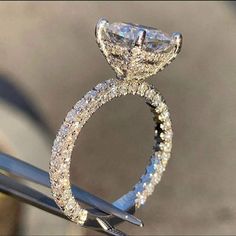 a diamond engagement ring sitting on top of a pair of scissors