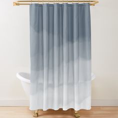 a shower curtain with a blue and white ombreed design on the bottom, in front of a bathtub