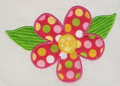 a pink flower with green leaves and polka dots on the petals is embroidered onto a white t - shirt