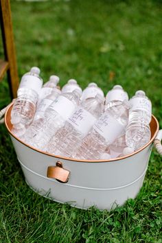 a bucket filled with water sitting on top of a lush green field