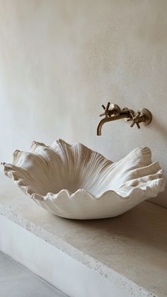 a white bowl sink sitting on top of a counter next to a faucet