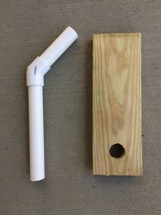 a white pipe is next to a piece of wood with a hole in the middle