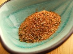 a blue bowl filled with spices on top of a wooden table