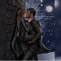 a man and woman are kissing in front of a brick wall with snow falling on the ground