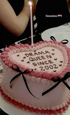 a heart shaped birthday cake with a lit candle