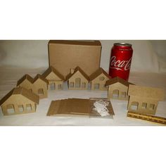 some cardboard houses and a soda can on a table