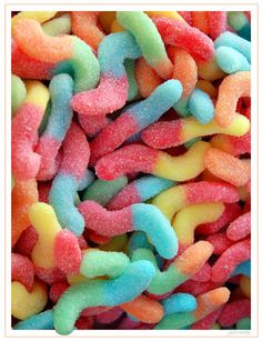 there are many different colored candies in the pile together and they look like worms