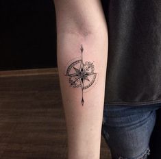 a person with a compass tattoo on their arm