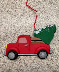 an ornament shaped like a red truck with a christmas tree on the back