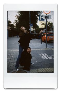 two people standing on the side of a street