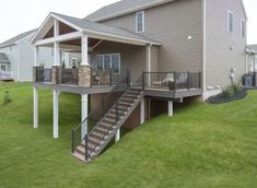 a house that has stairs leading to the front door and second story with an attached deck