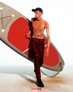 a man with no shirt holding a surfboard