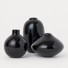 three black vases sitting next to each other