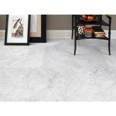 white marble flooring in a living room with pictures on the wall and side table