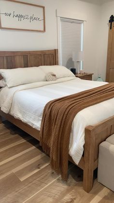 a large bed sitting on top of a hard wood floor next to a wooden dresser