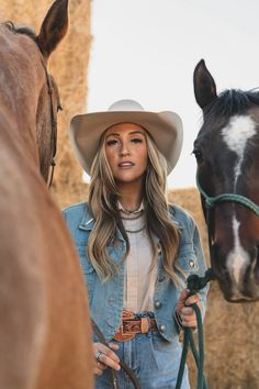 a beautiful woman standing next to a brown horse